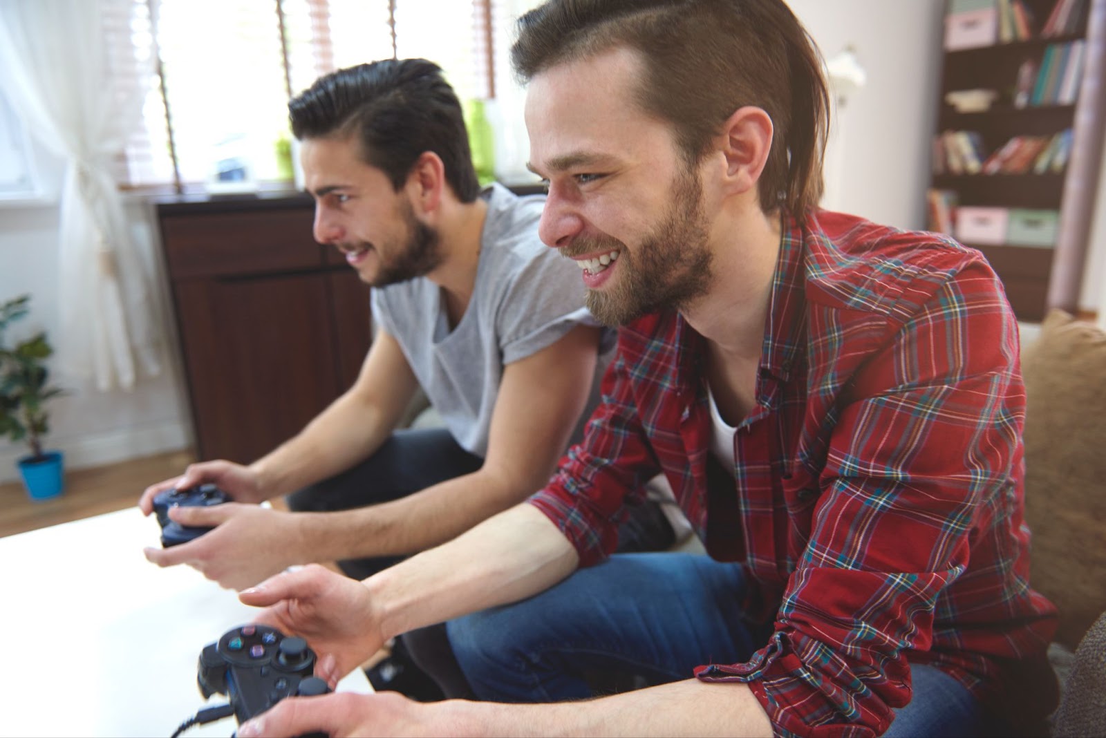 two affectionate bearded guys playing a game on a PlayStation console